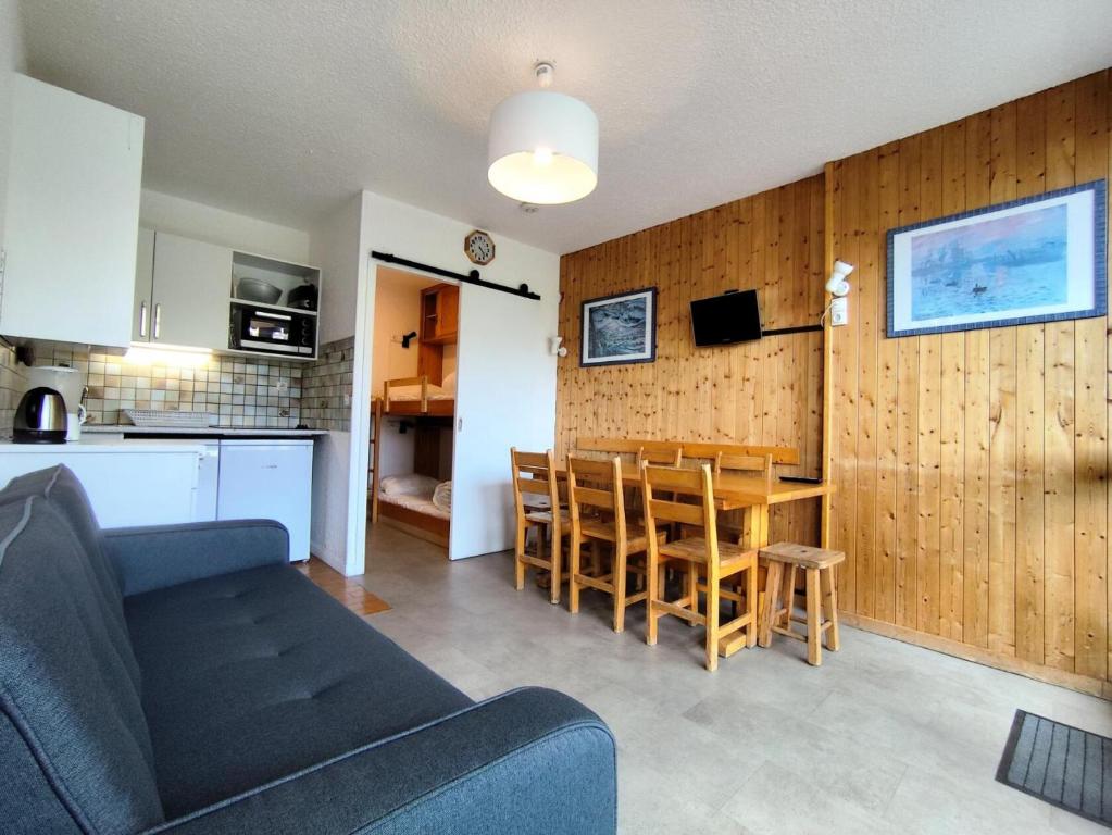 un salon et une cuisine avec un canapé et une table dans l'établissement Résidence Lac Du Lou - VAL THORENS location: Appartement de 38 m2 au 7ème étage, skis aux pieds, balcon exposé sud MAE-9021, à Val Thorens
