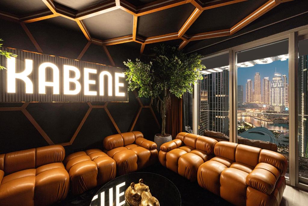 ドバイにあるKabene Exotic, Burj Khalifa & Fountain View, 5 Starts, 4 Bedroom, Best In Dubaiの革張りのソファと大きな窓のあるリビングルーム