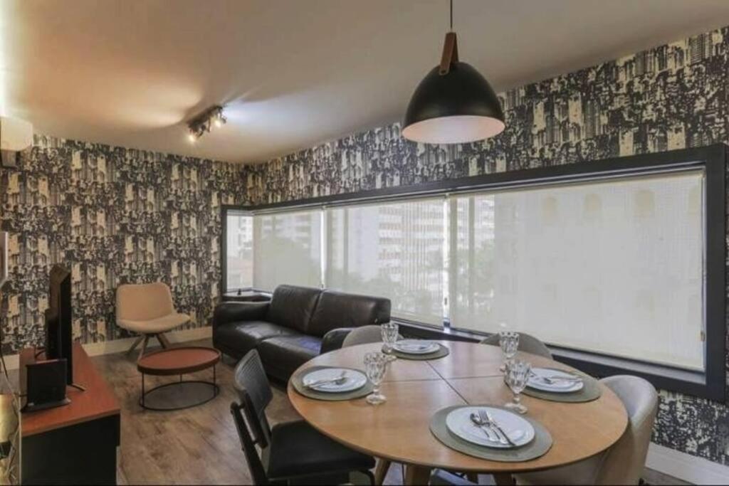 un salon avec une table et un canapé dans l'établissement Vn Al Campinas Refugio Moderno, à São Paulo