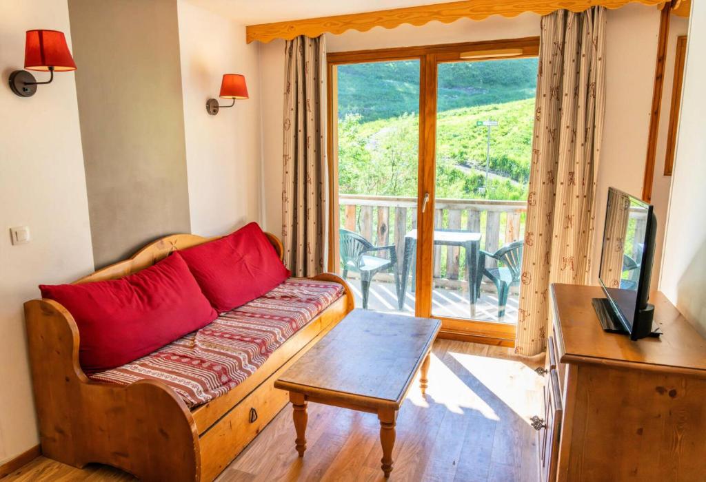un salon avec un canapé et une grande fenêtre dans l'établissement Résidence Les Hauts De Preclaux - Appartement avec balcon ensoleillé face aux pistes MAE-7061, aux Orres