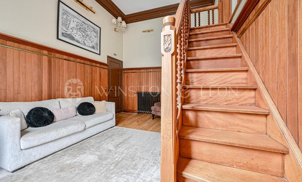 un salon avec un canapé et un escalier dans l'établissement Studio Paris 7e Tour Eiffel, à Paris