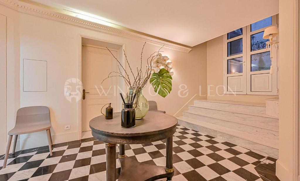 une chambre avec une table et un vase avec des fleurs dans l'établissement Appartement Tour Eiffel Invalides 7e G, à Paris