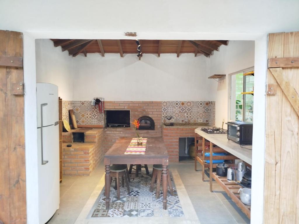 a kitchen with a wooden table and a fireplace at Sítio La Paz in Morretes