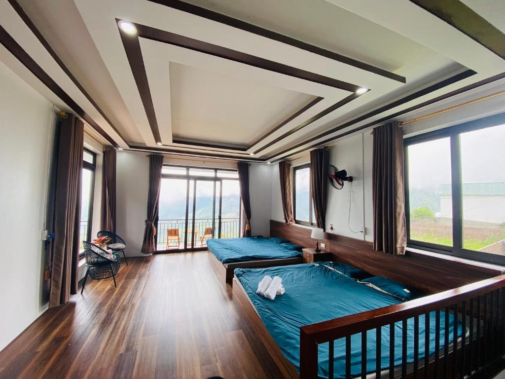 une chambre avec deux lits dans une pièce avec fenêtres dans l'établissement Saigonese Villa, à Sa Pa