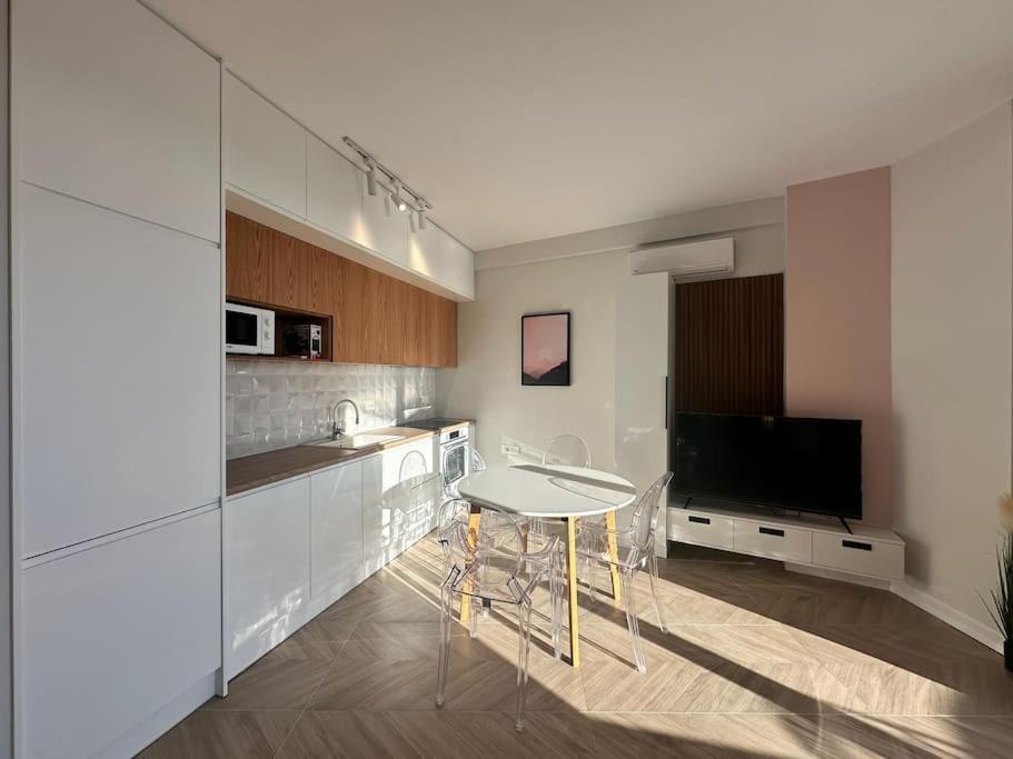a kitchen with a table and a tv in it at Vanessa Apartment in Sarandë