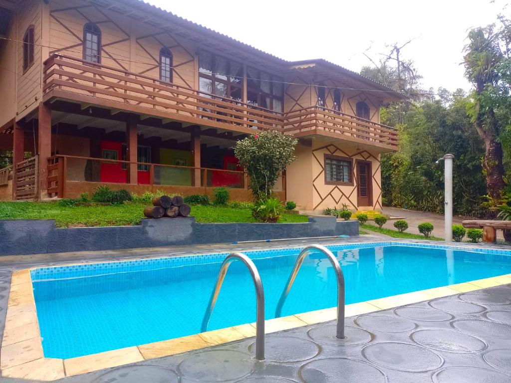 a house with a swimming pool in front of it at Chácara Sonho Meu Juquitiba SP in Juquitiba