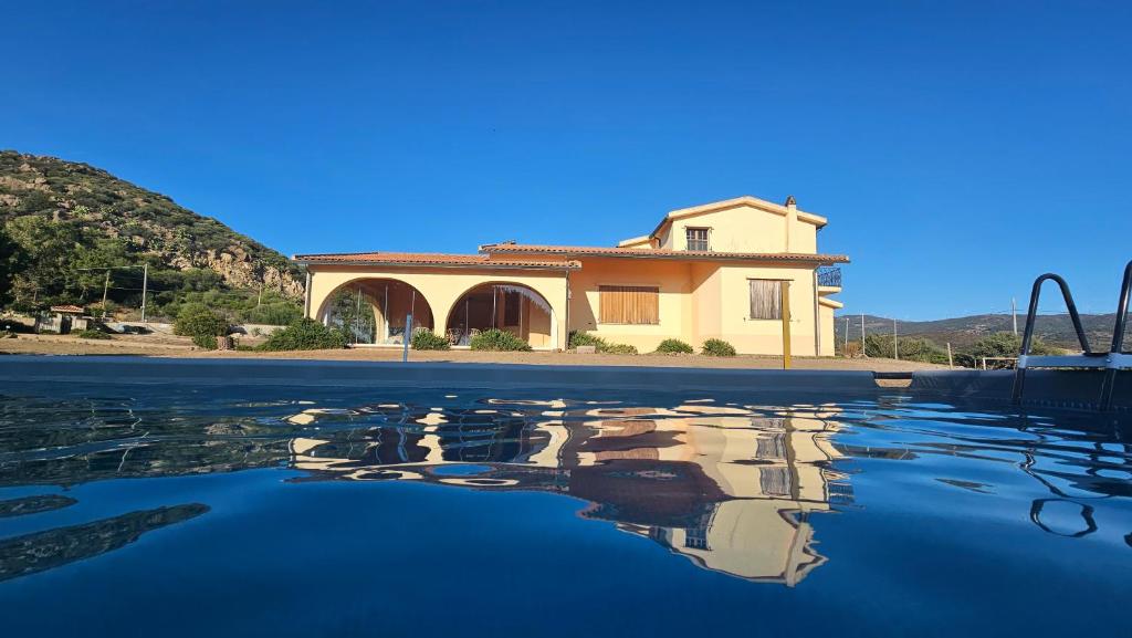 una casa con su reflejo en el agua en Villa Jolies, en Viddalba