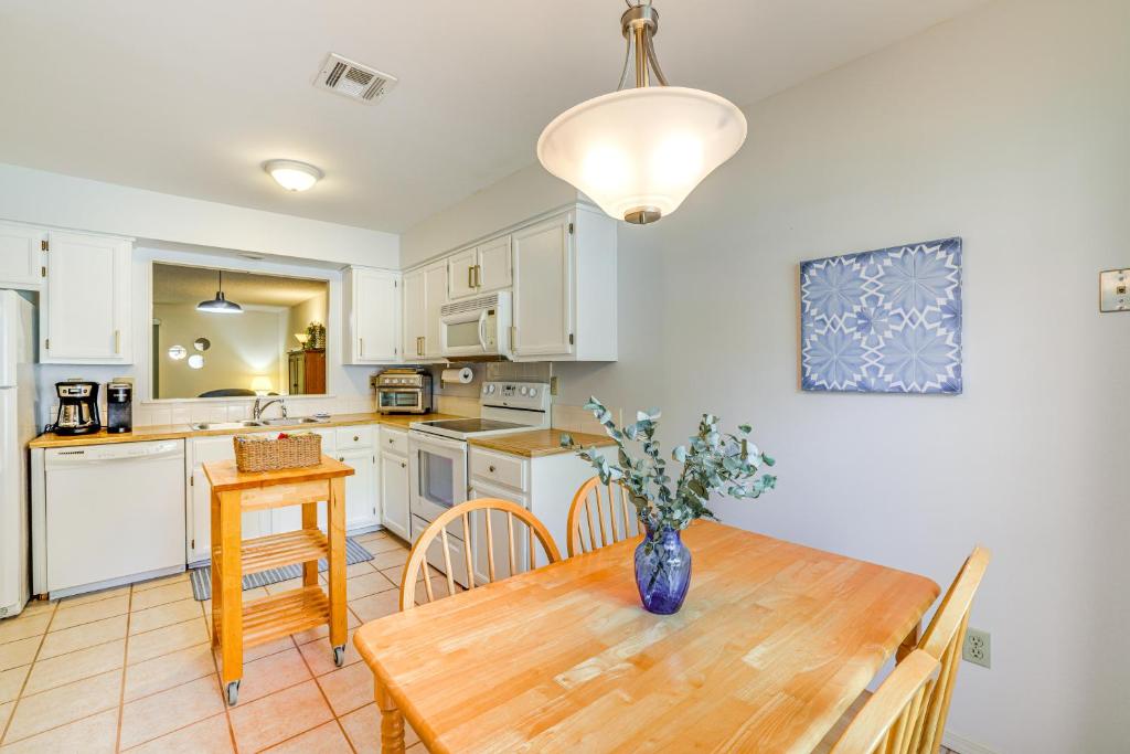 a kitchen with a wooden table with a vase on it at Bella Vista Townhome with Deck Near Back 40 Trail! in Bella Vista