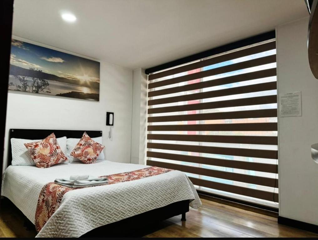 a bedroom with a bed and a large window at Hotel Naisca 47 in Pasto