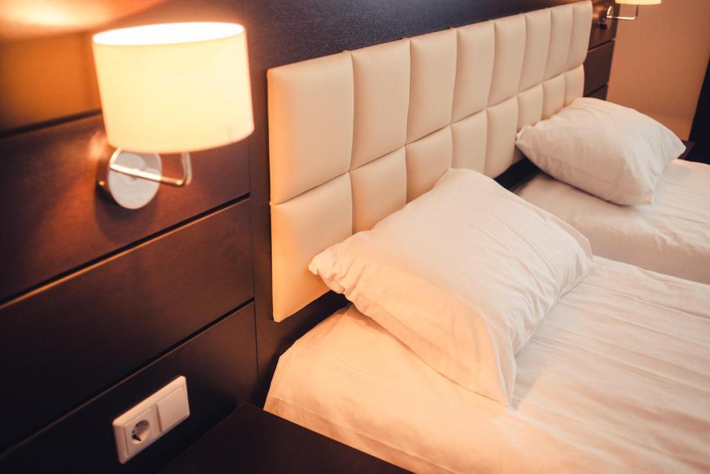 une chambre d'hôtel avec deux lits et une lampe dans l'établissement Ostrovsky Hotel, à Kazan