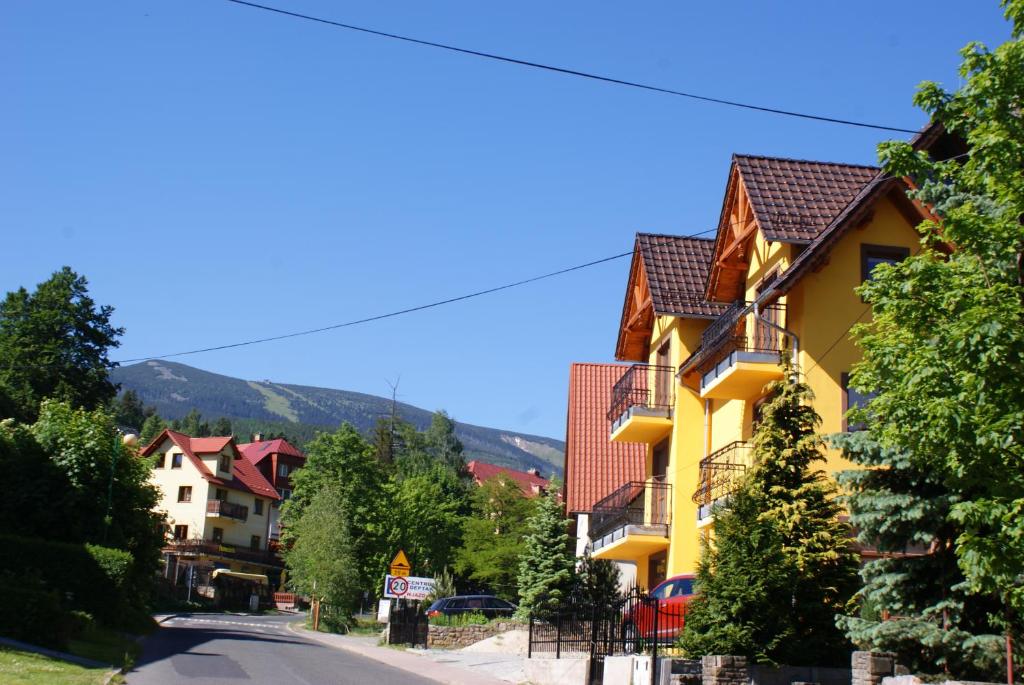 un edificio amarillo al lado de una calle en DARIA pokoje gościnne en Karpacz