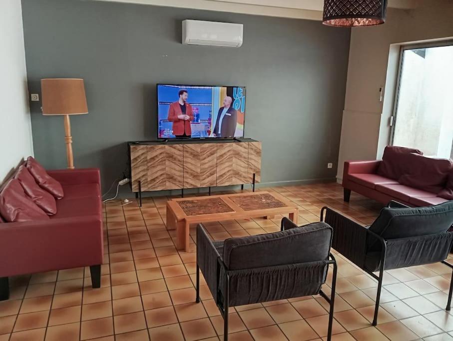 un salon avec une télévision à écran plat sur une table dans l'établissement Maison 3 lits jardinet Montguyon lac et plage a 5 mn, à Montguyon
