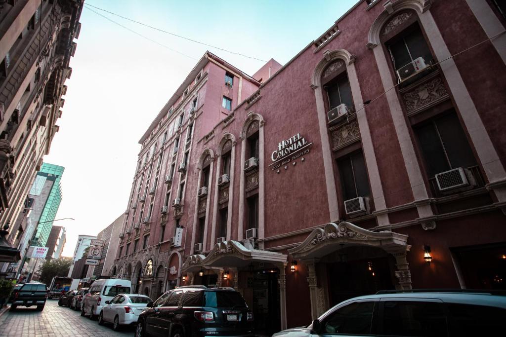 a city street with cars parked in front of buildings at Hotel Colonial in Monterrey