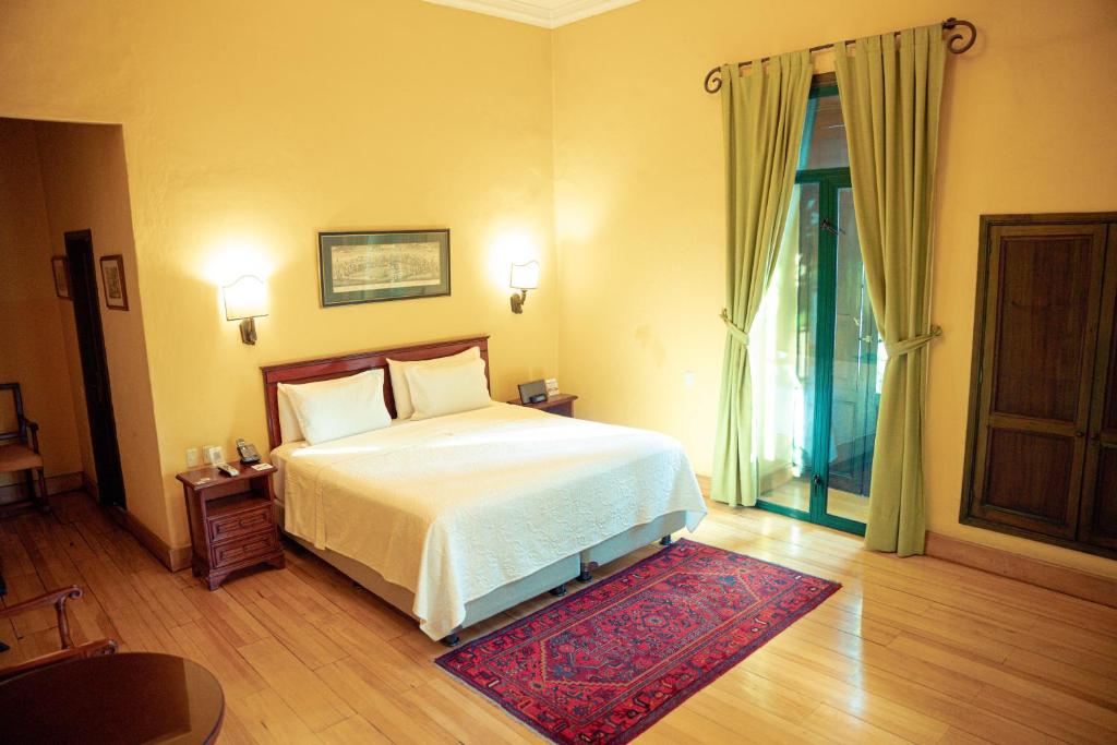 ボゴタにあるHotel De La Operaのベッドルーム1室(ベッド1台、赤いラグ付)
