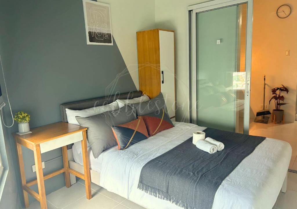 a bedroom with a bed with a nightstand and a bed sidx sidx at SM Mezza 1 Residences in Manila