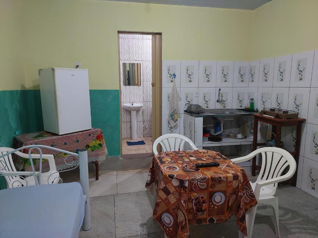 a kitchen with a table and chairs and a refrigerator at Casa para temporada in Belém