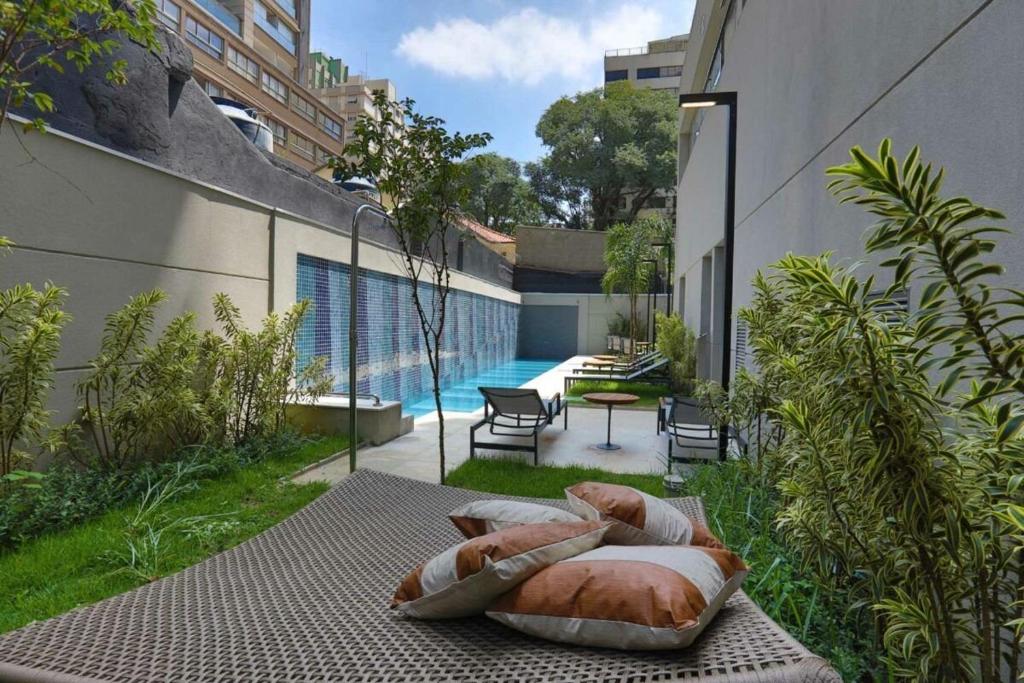 ein Bett auf einem Tisch neben einem Pool in der Unterkunft Handy Paraíso condomínio com piscina ao lado do Ibirapuera in São Paulo