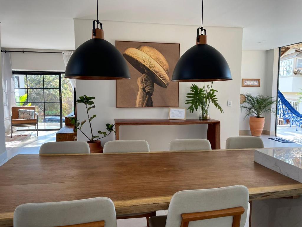 a dining room with a large wooden table and chairs at Casa Paraíso in Pirenópolis