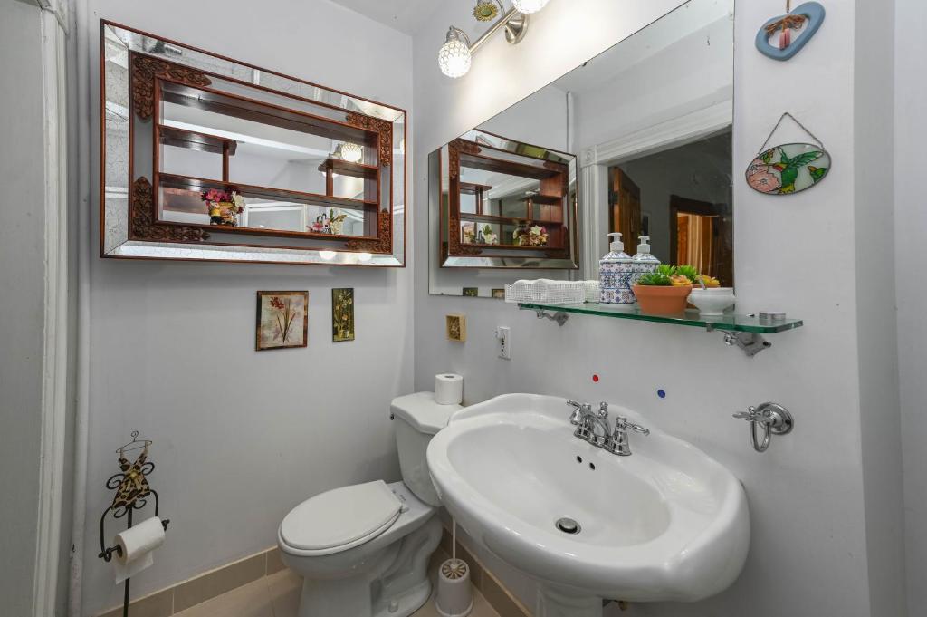 un bagno con lavandino, water e specchio di Niagara Inn Bed and Breakfast a Niagara Falls