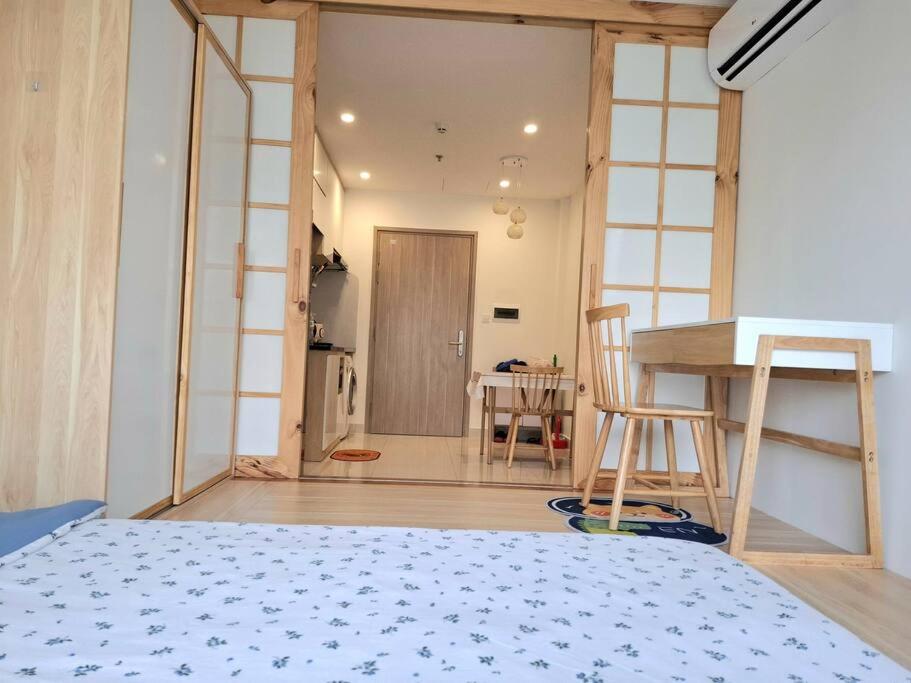 a room with a bed and a kitchen with a table at EcoVinhomes Grand Park in Long Bình