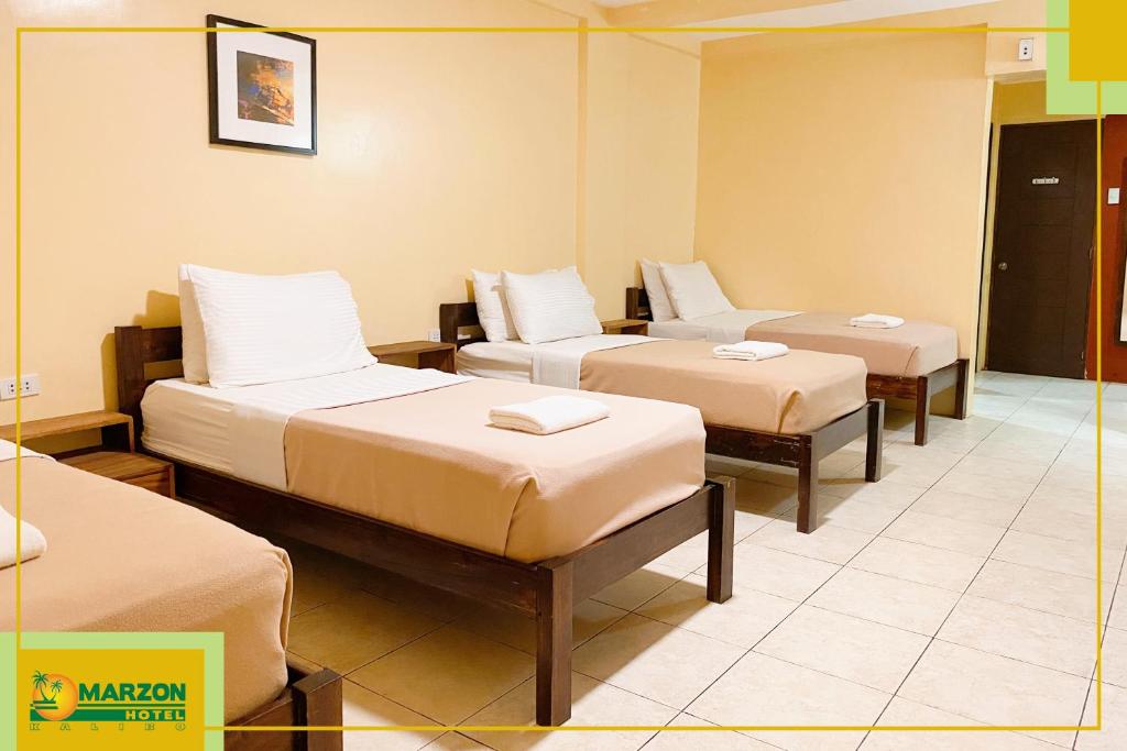 Postel nebo postele na pokoji v ubytování MARZON HOTEL KALIBO