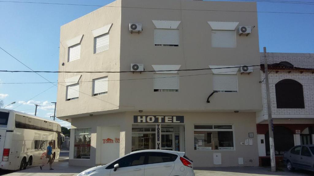 un coche blanco estacionado frente a un hotel en Hotel Torrevado en Las Grutas