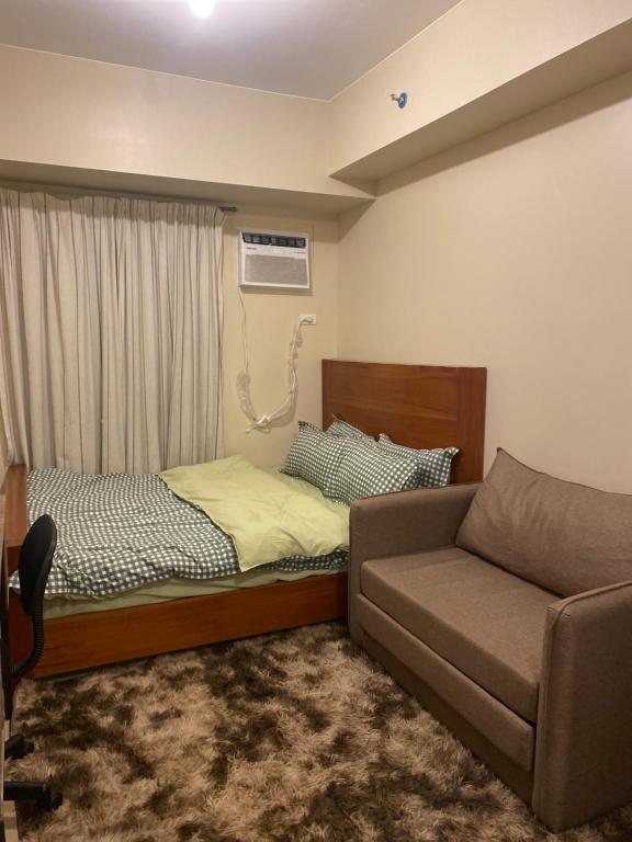 イロイロにあるAvida Towers Atriaのベッドとソファのあるリビングルーム