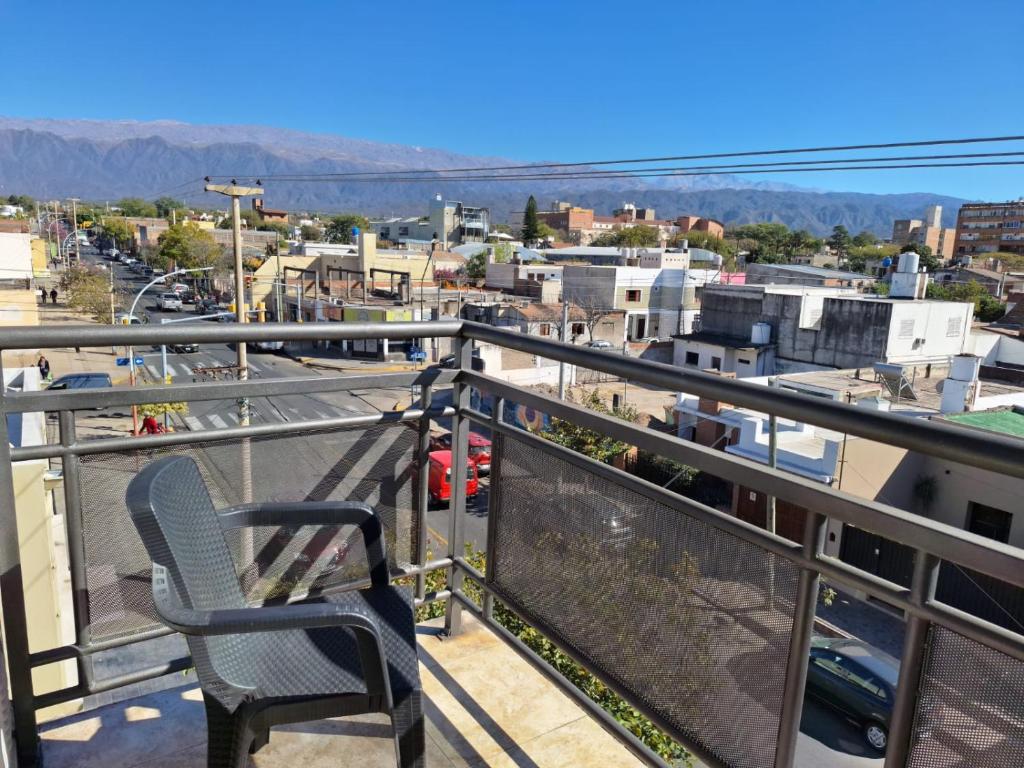 a chair sitting on a balcony overlooking a city at Departamentos Güemes in San Fernando del Valle de Catamarca