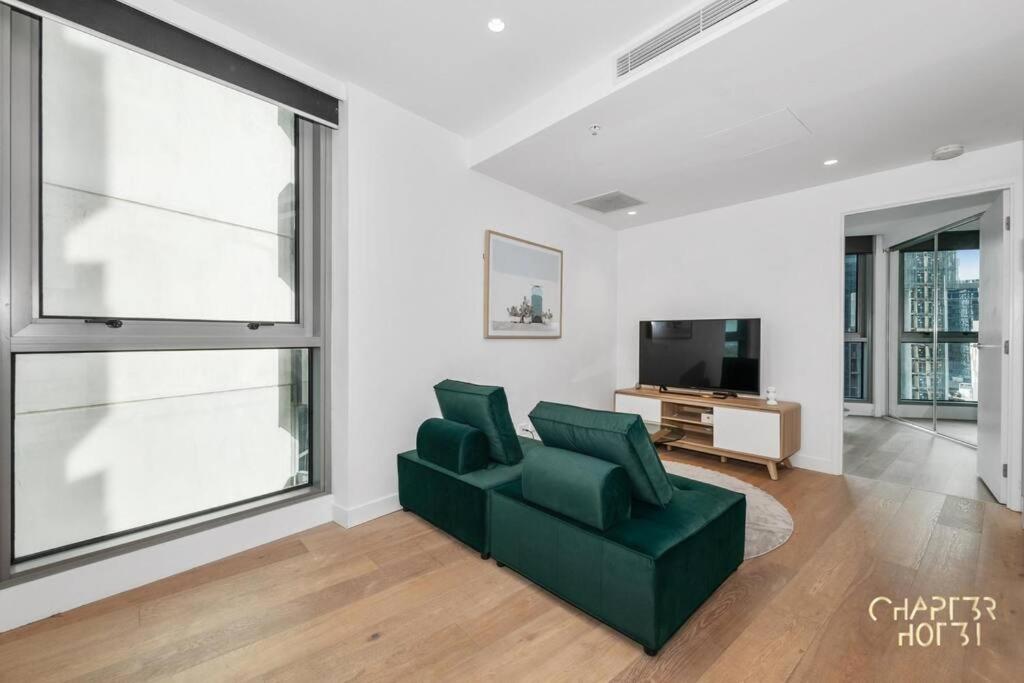 un soggiorno con divano verde e TV di Chapter 3 in Imagine Macro Hotel a Melbourne