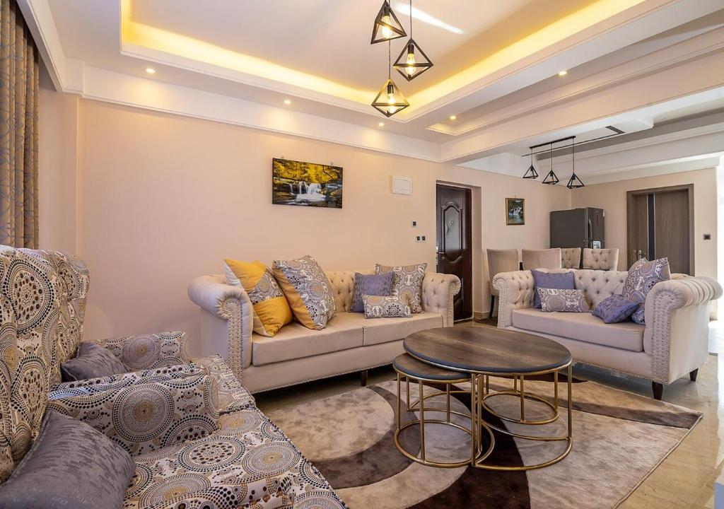 a living room with couches and a table at Luxurious 3 Bed 4 Bath Condo in Nairobi
