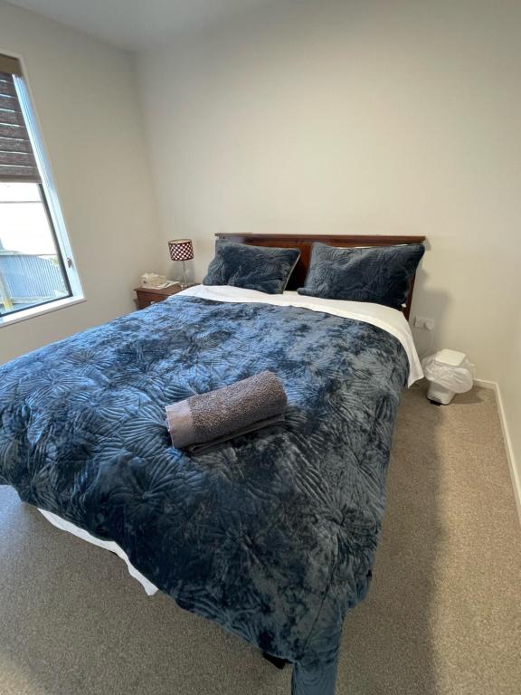 基督城Bryndwr Accommodation的一间卧室配有一张带蓝色棉被的大床