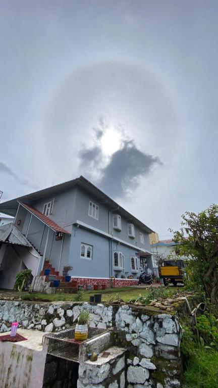 a large building with a stone wall in front of it at Lijo Ruban Home Stay in Kodaikānāl