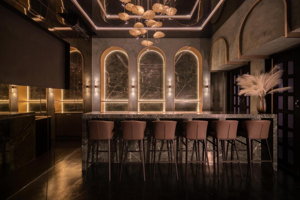 a bar in a room with a bunch of stools at Cube Social Boutique Capsule Hotel at Boat Quay in Singapore