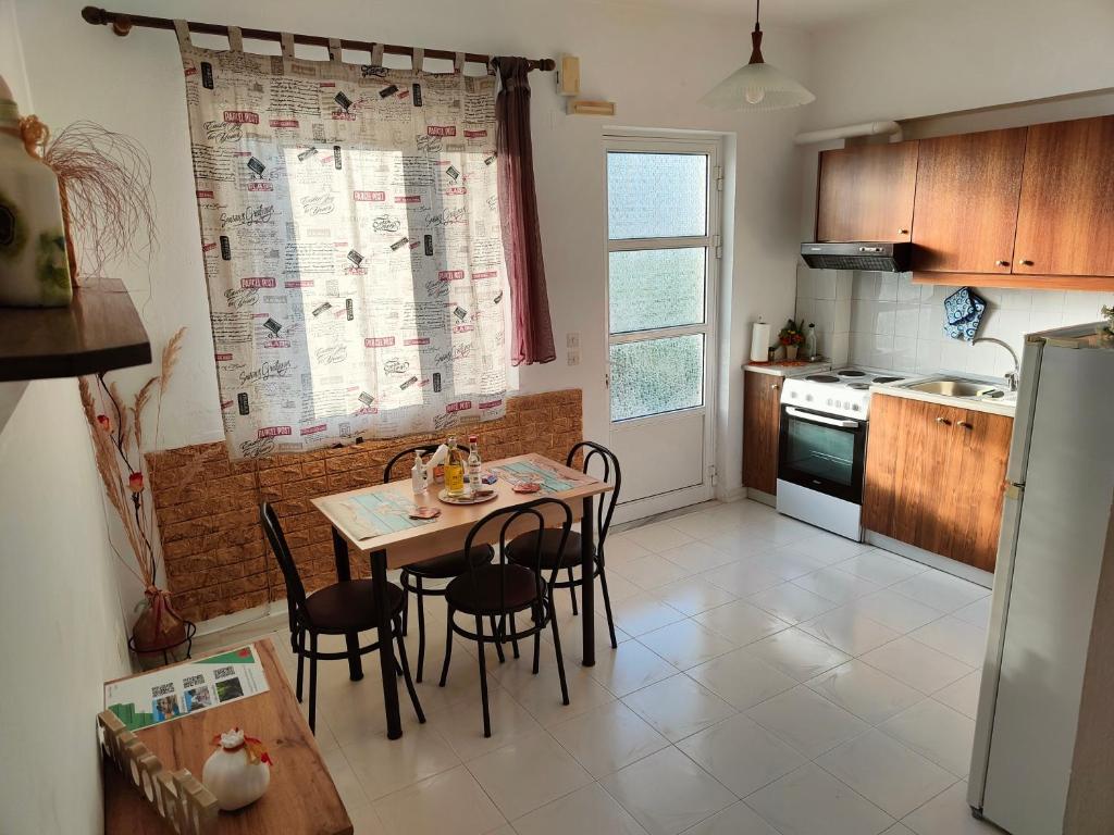 kuchnia ze stołem, krzesłami i lodówką w obiekcie Hibiscus Green Apartments w mieście Afandu