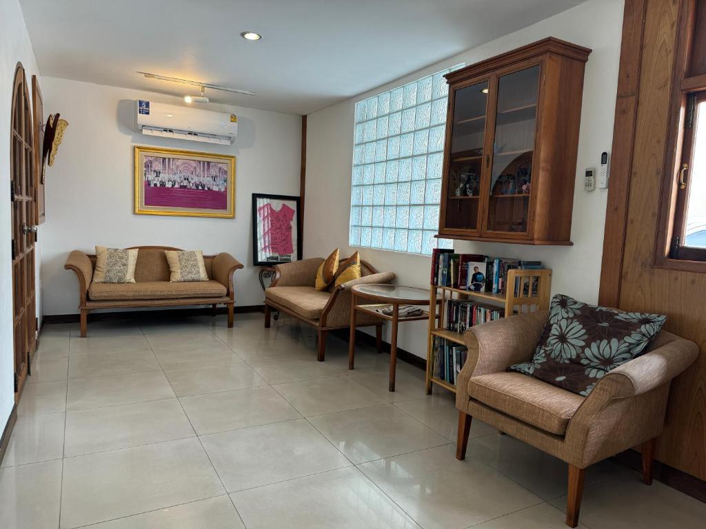 A larger angle on the hotel sitting room, with sofas, armchairs, books and a bright window wall.