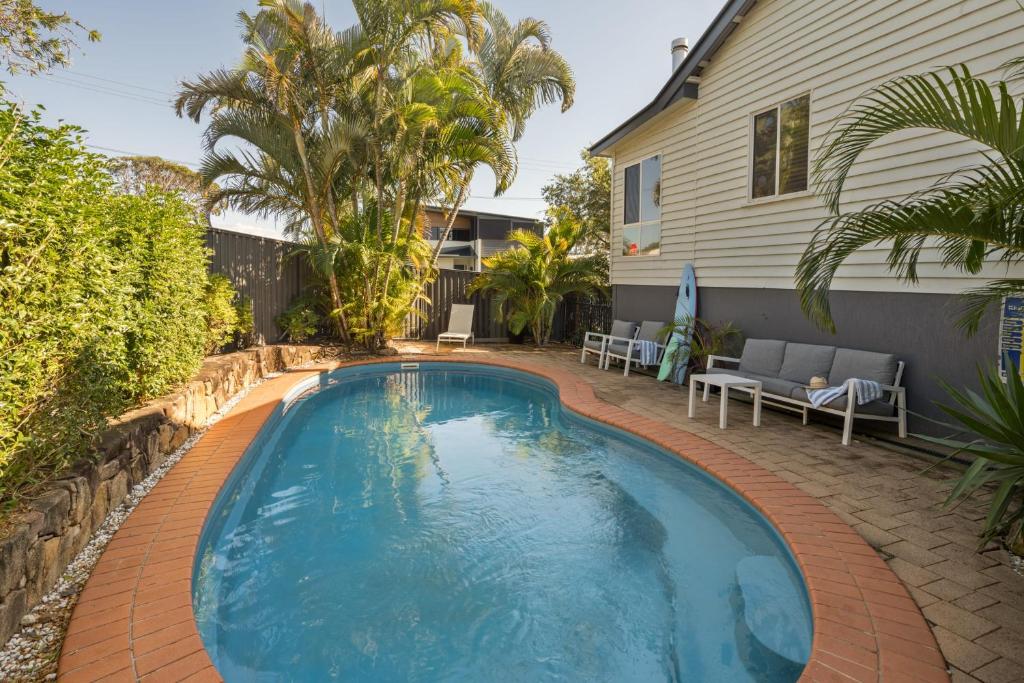 a swimming pool in the backyard of a house at Moffat Beach Retreat, Pet-friendly & Ocean Views in Caloundra