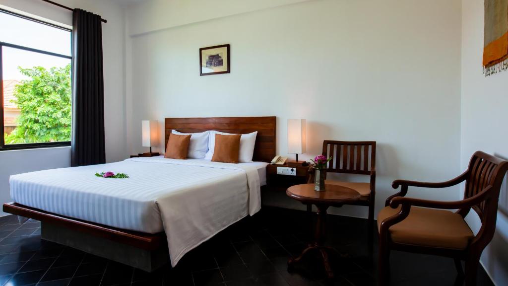 Postel nebo postele na pokoji v ubytování Kingdom Angkor Hotel