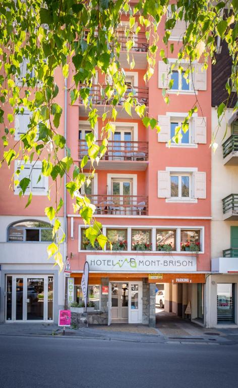 a pink building with a north entrance on a street at Hôtel Mont-Brison in Briançon