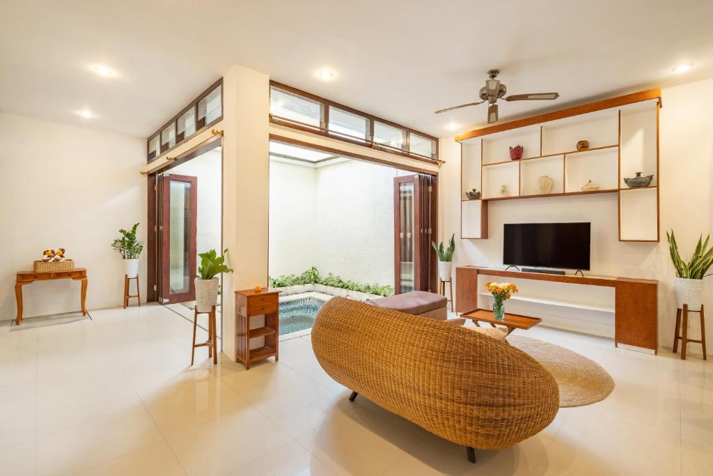 a living room with a couch and a television at Seven Residence in Seminyak