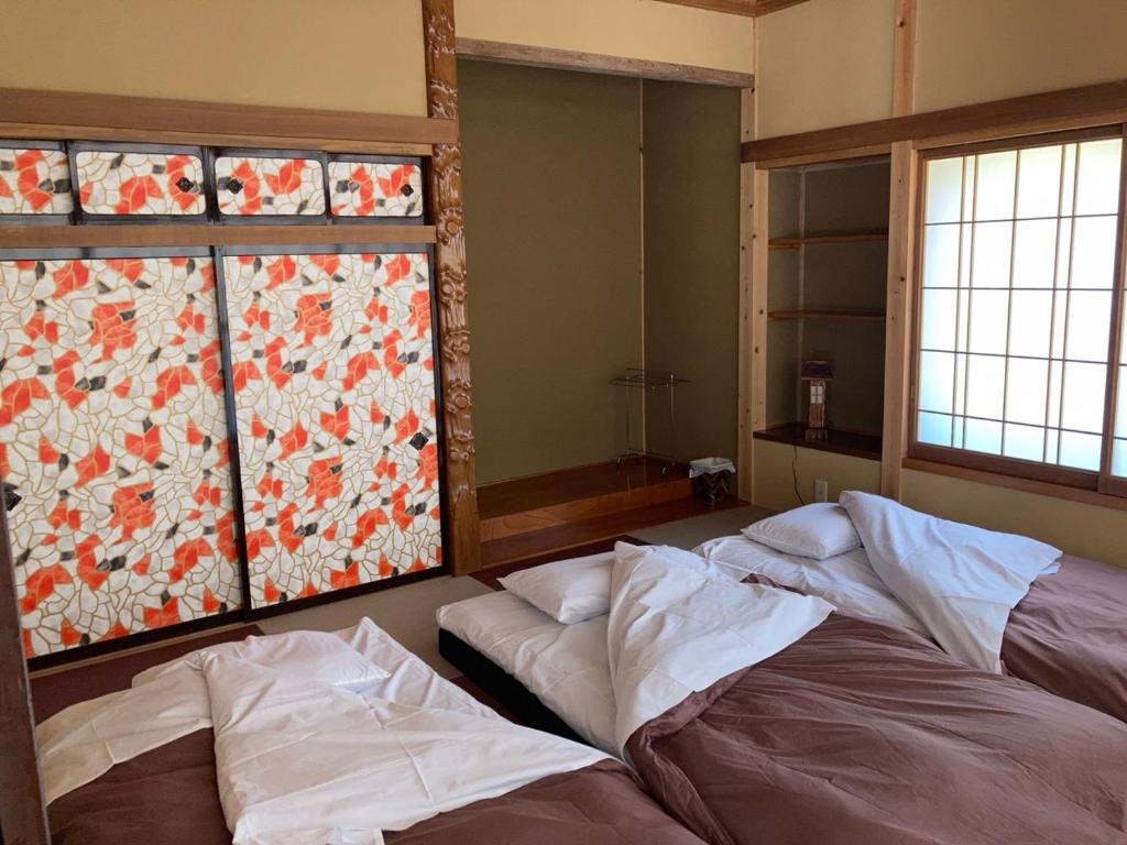 Postel nebo postele na pokoji v ubytování 安曇野市穂高温泉郷Vila湯仙望