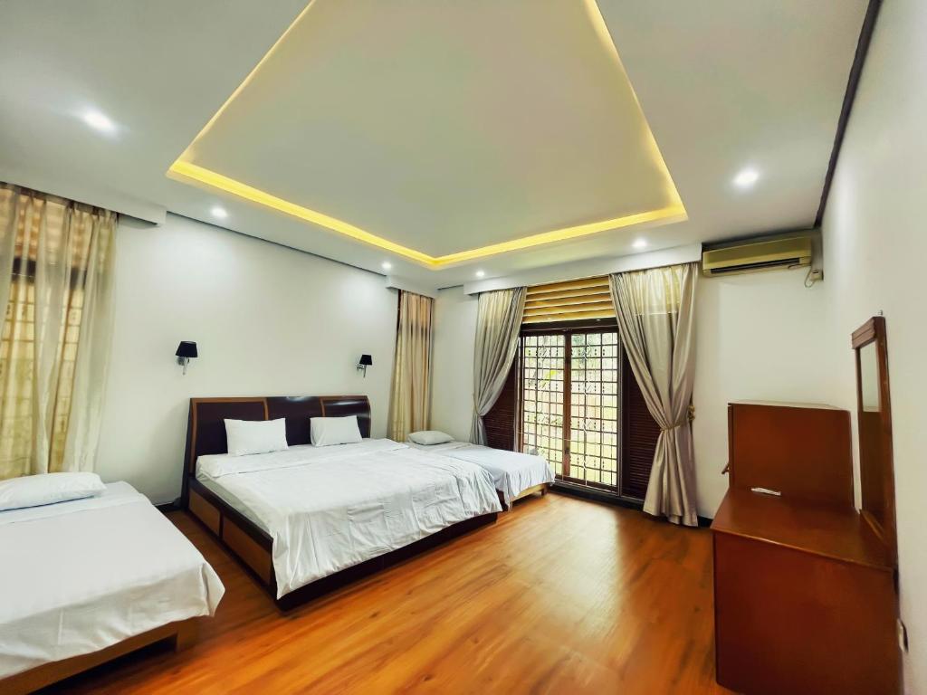 a bedroom with two beds and a large window at Villa Bango in Cilember Udik 1