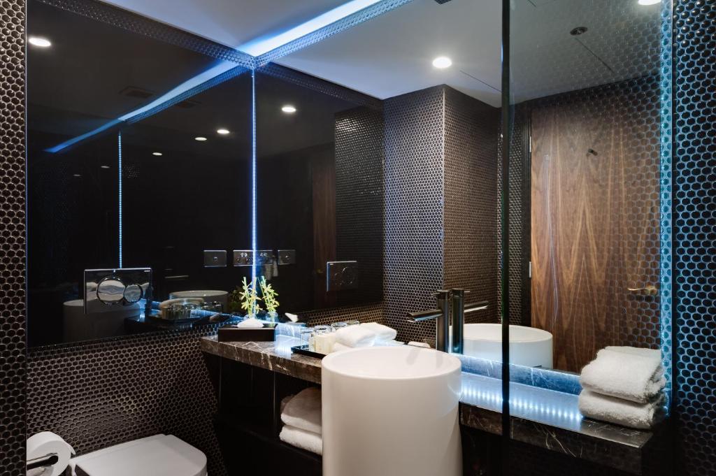 a bathroom with a toilet and a sink and a tub at Stamford Plaza Melbourne in Melbourne