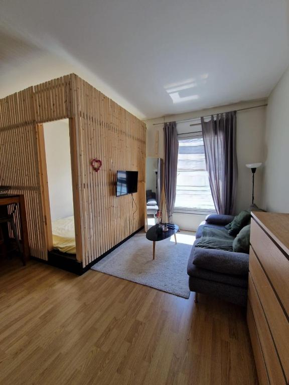 un salon avec un canapé et un miroir dans l'établissement Studio cosy coeur paris - quartier Opéra, à Paris