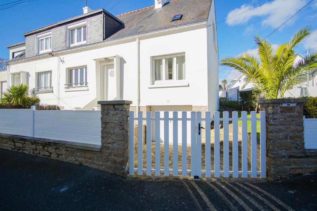 une clôture blanche devant une maison blanche dans l'établissement -HORTENSE- MAISON SABLES BLANCS Á 300M DES PLAGES, à Concarneau
