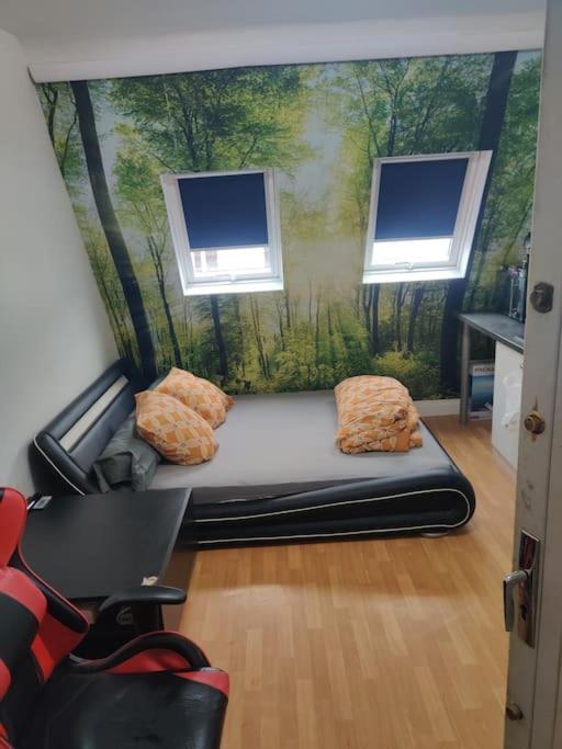 Cette chambre comprend un canapé et une fresque murale représentant la forêt. dans l'établissement studio cosy Paris 9, à Paris