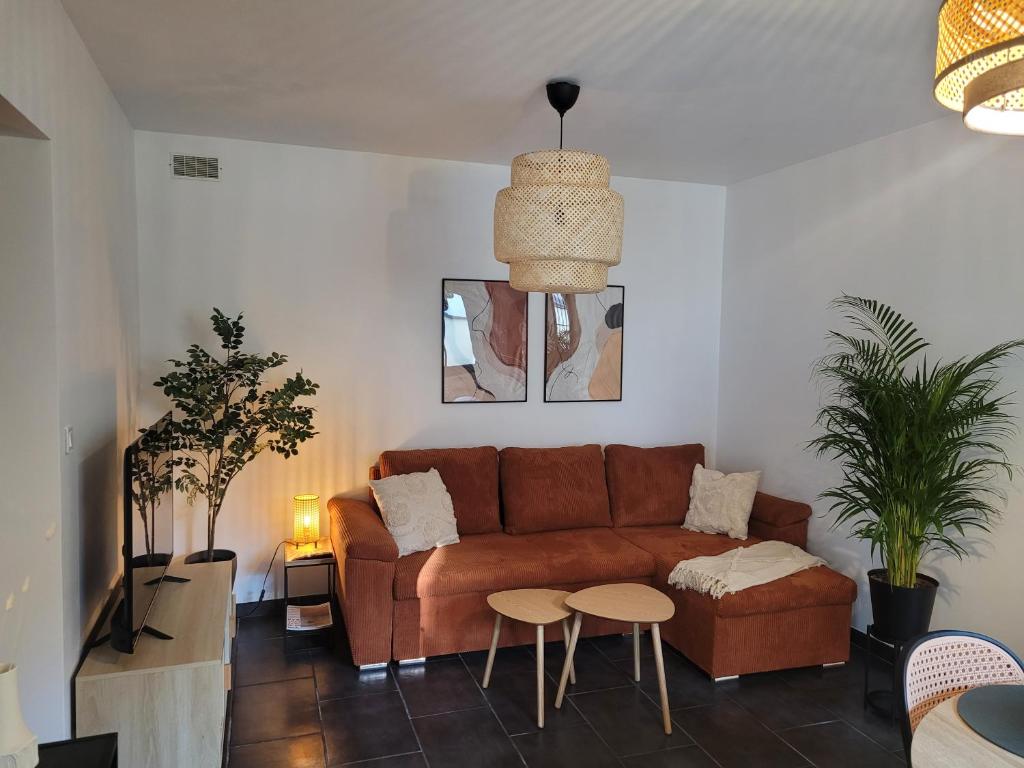 - un salon avec un canapé brun et 2 tables dans l'établissement Appartement cosy avec exterieur au coeur de la Provence, à Monteux
