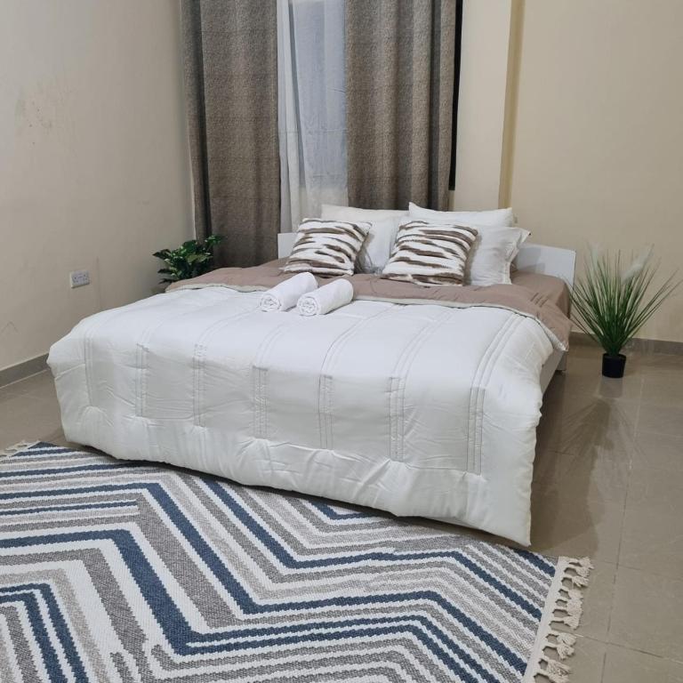 Postel nebo postele na pokoji v ubytování Stylish Stay Free Wi-Fi, Kitchen, Near Mussafah & Abu Dhabi City