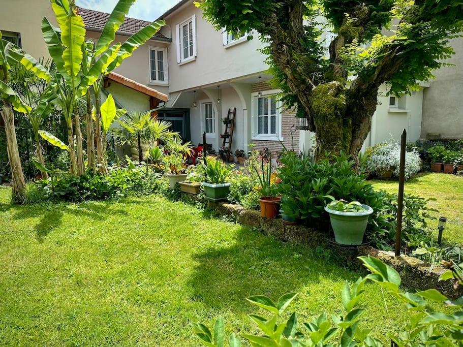 un jardin en face d'une maison ornée de plantes dans l'établissement La terrasse fleurie, à Salies-du-Salat