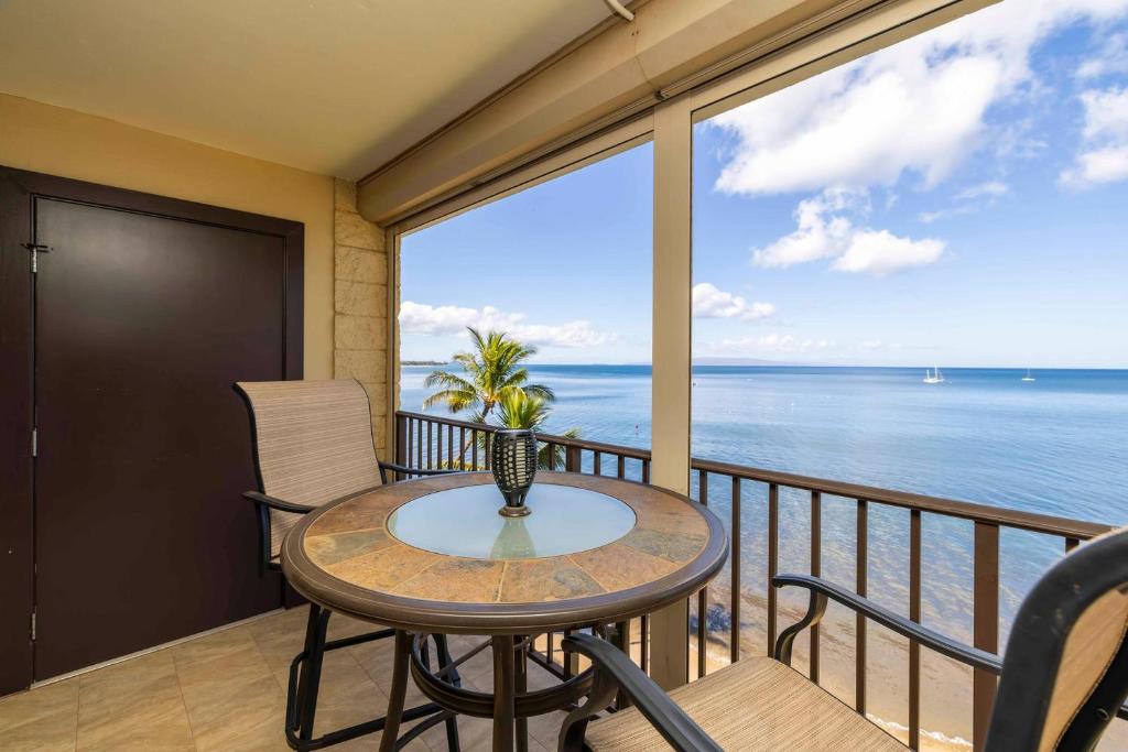 a balcony with a table and chairs and the ocean at Kihei Beach Resort 608 in Kihei