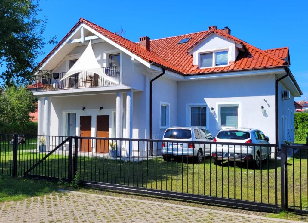a house with two cars parked in front of it at Cicha 3 in Sztutowo